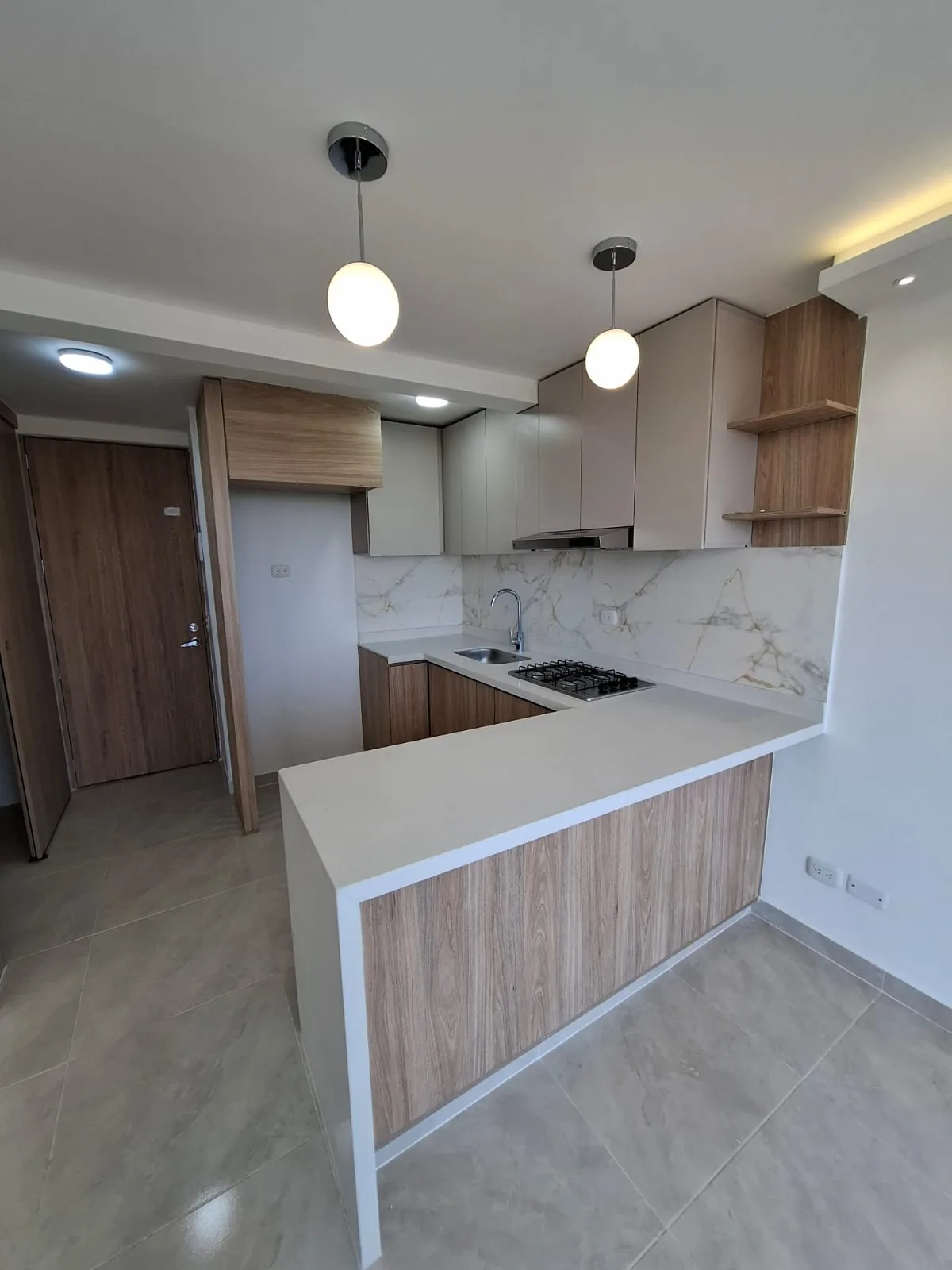 Cocina con mesón blanco y muebles en madera clara