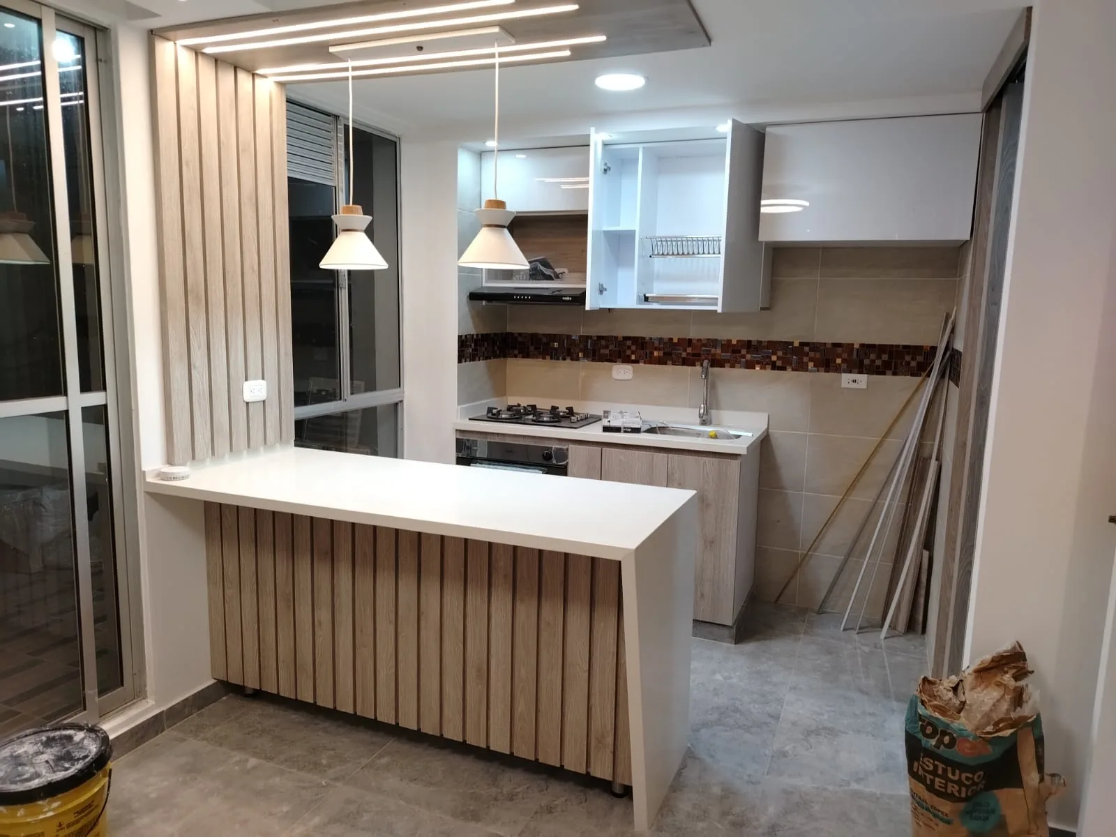 Cocina con isla en cuarzo e iluminación colgante