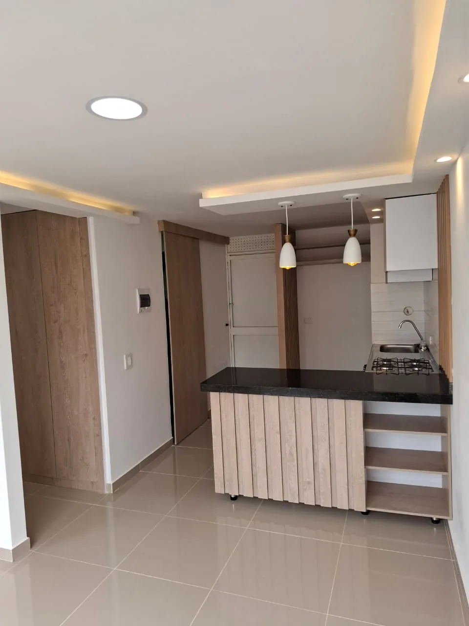 Cocina con barra en listones de madera abierta a la sala